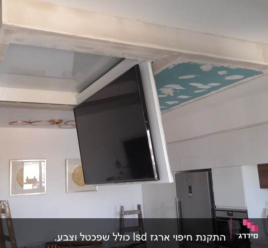 תקרת גבס עם טלוויזיה תלויה בתהליך התקנה